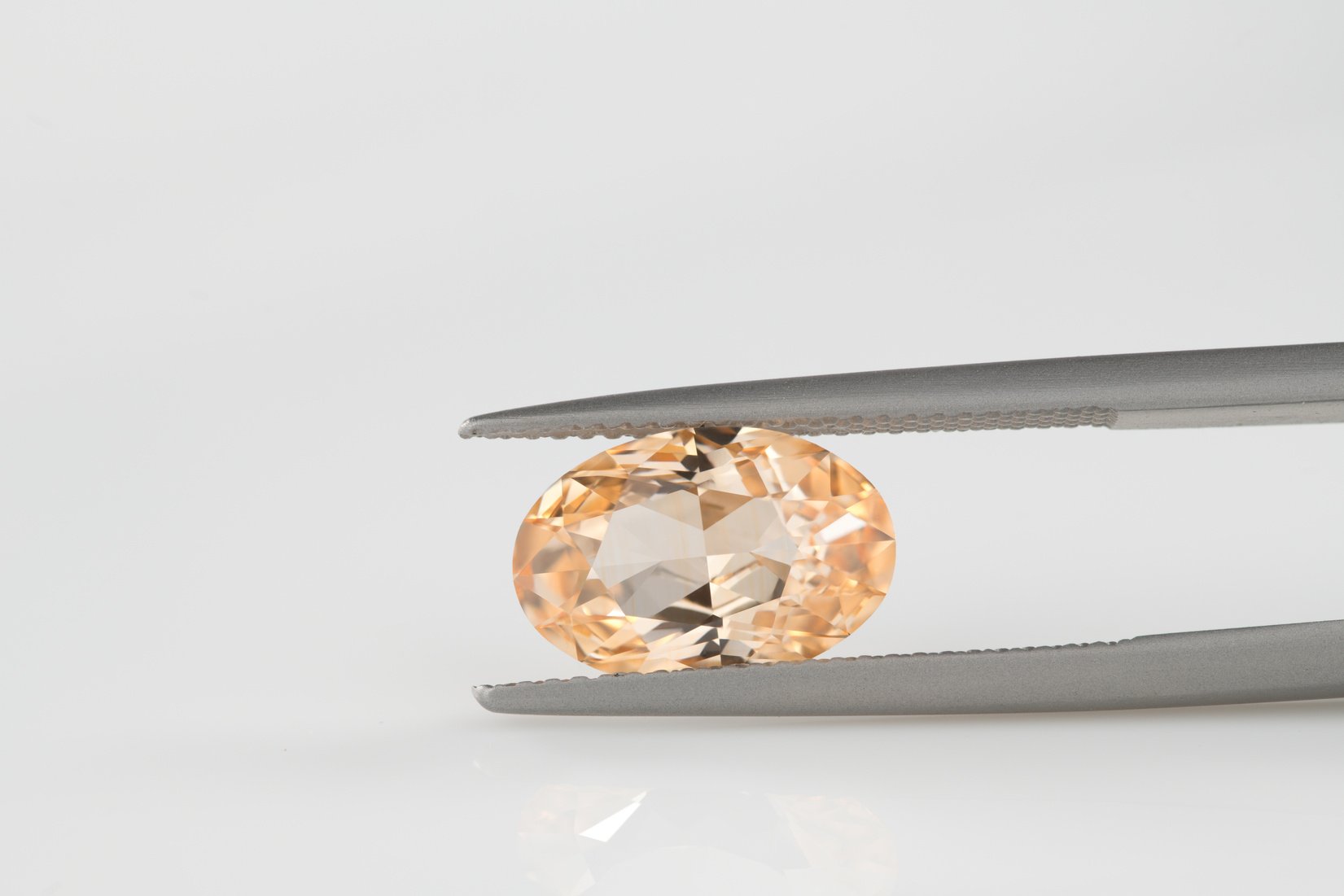 Oval Cut yellow Sapphire gemstone in Jewelry tweezers